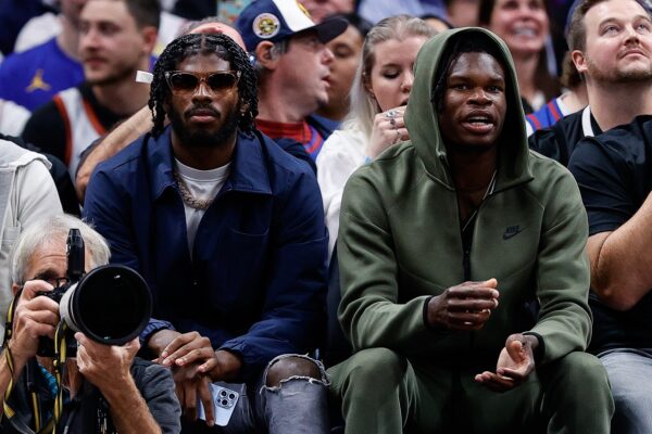 Oct 24, 2023; Denver, Colorado, USA; University of Colorado Buffaloes football players Shedeur Sanders (L) and Travis Hunter (R) watch during the third period between the Denver Nuggets and the Los Angeles Lakers at Ball Arena.