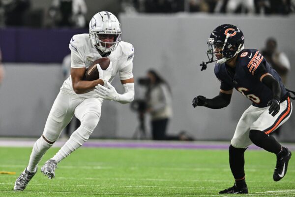 Minnesota Vikings wide receiver Justin Jefferson (18) runs after the catch as Chicago Bears cornerback Kyler Gordon (6) defends during the second quarter at U.S. Bank Stadium.