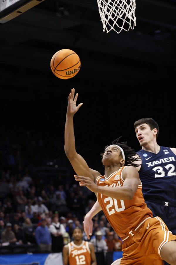 Texas Longhorns guard Tre Johnson (20) shoots the ball pressured by Xavier Musketeers forward Zach Freemantle (32) in the first half at UD Arena.