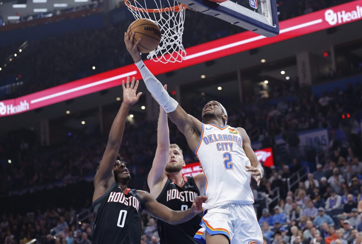 Oklahoma City Thunder guard Shai Gilgeous-Alexander (2) shoots in front of Houston Rockets guard Aaron Holiday (0) and h during the second quarter at Paycom Center.