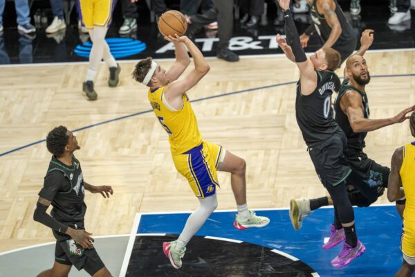 Los Angeles Lakers guard Austin Reaves (15) shoots a game winning shot over Minnesota Timberwolves guard Donte DiVincenzo (0) in the second half at Target Center.