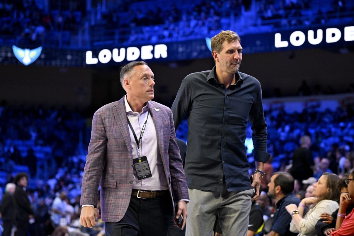 Dallas Wings CEO Greg Bibb (left) and former NBA player Dirk Nowitzki (right) walk off the floor after the game between the Dallas Wings and the Seattle Storm at College Park Center.