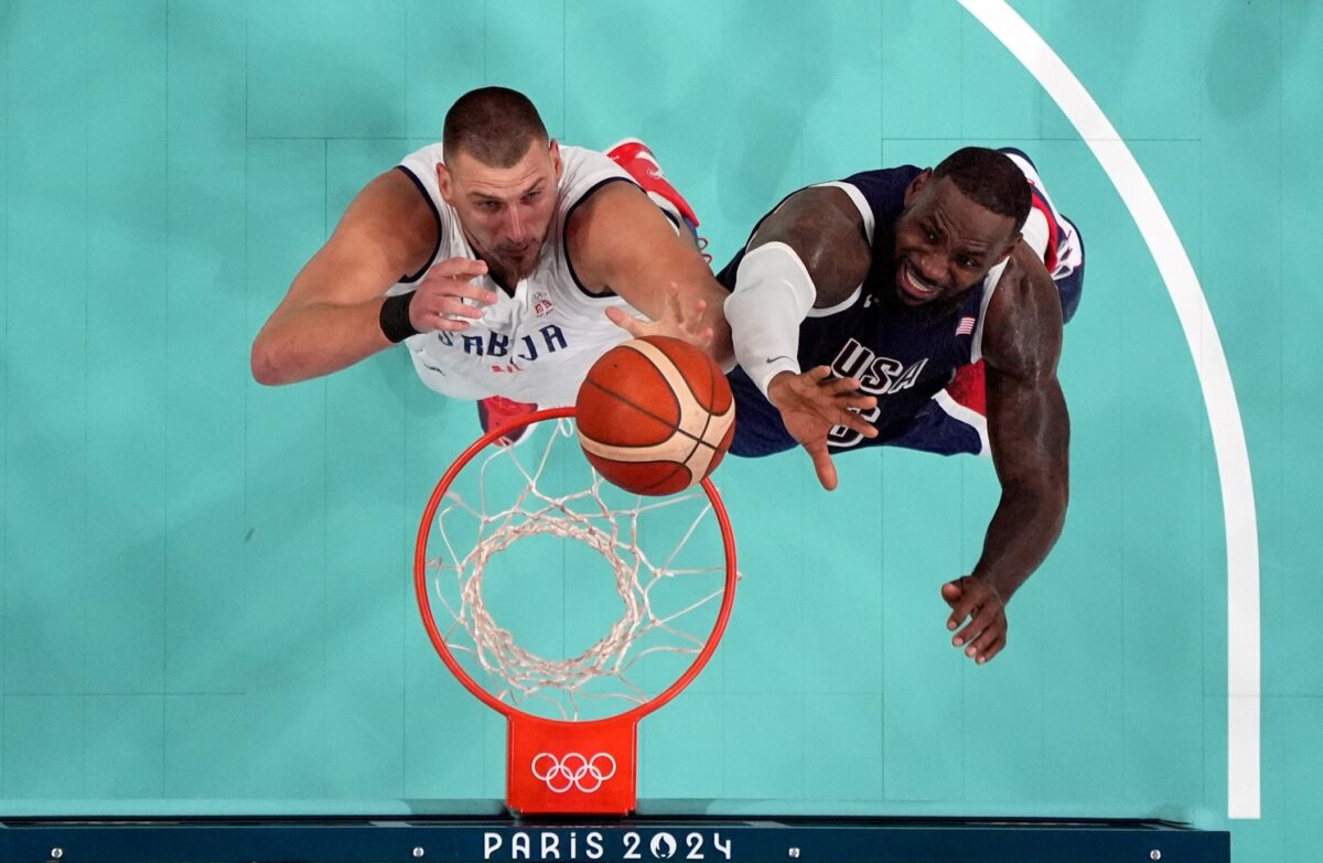 Serbia power forward Nikola Jokic (15) and United States guard Lebron James (6) jump for a rebound in the fourth quarter during the Paris 2024 Olympic Summer Games at Stade Pierre-Mauroy.