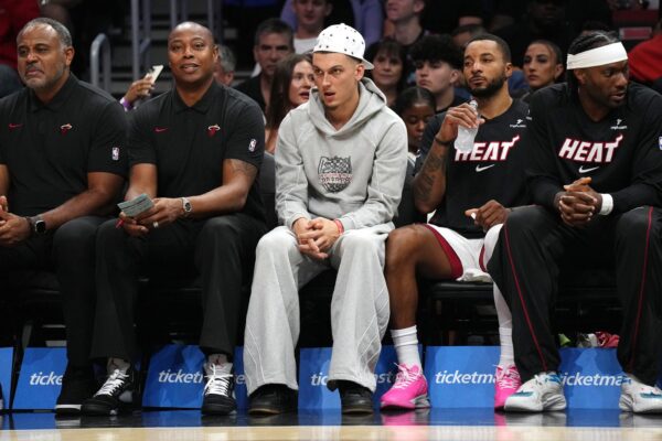 Miami Heat guard Tyler Herro, center, watches the game against the San Antonio Spurs from the bench at Kaseya Center as he recovers from an injury.