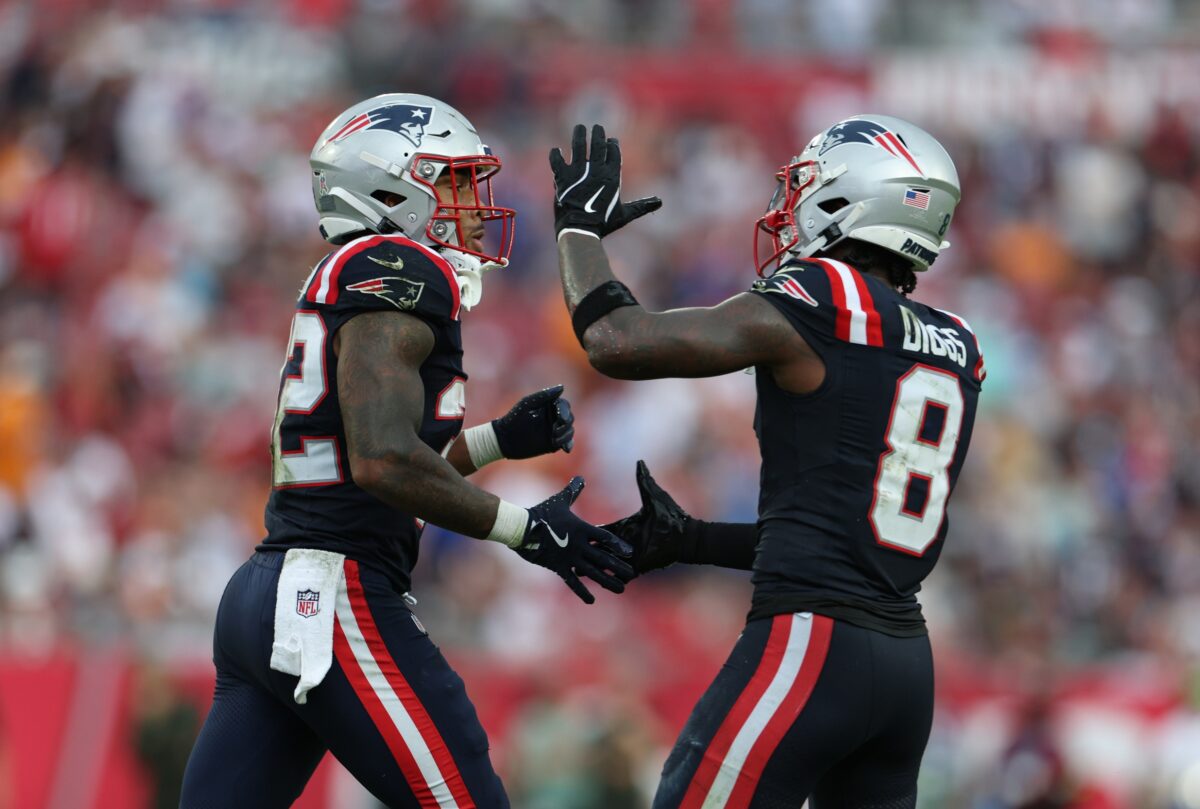 New England Patriots running back Treveyon Henderson (32) and wide receiver Stefon Diggs (8) celebrate a touchdown during the third quarter against the Tampa Bay Buccaneers at Raymond James Stadium.