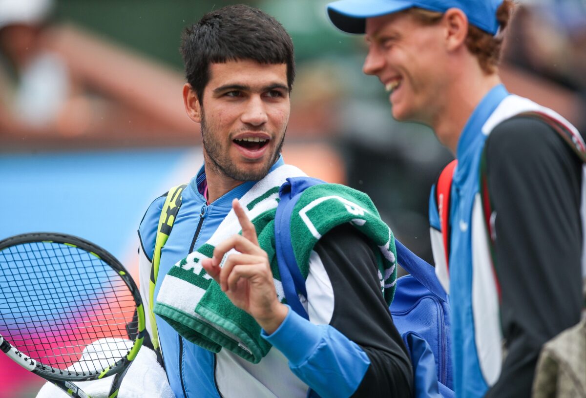 Carlos Alcaraz and Jannik Sinner chat while leaving the court for a rain delay at the BNP Paribas Open in Indian Wells, Calif., March 16, 2024.