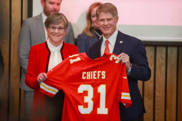 Kansas Gov. Laura Kelly and Kansas City Chiefs CEO Clark Hunt hold up a Chiefs jersey.