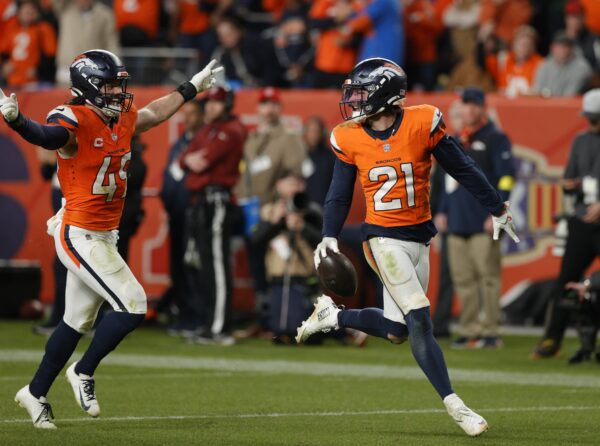 Denver Broncos cornerback Riley Moss (21) and linebacker Alex Singleton (49) celebrate following an interception during the fourth quarter against the Green Bay Packers at Empower Field at Mile High.