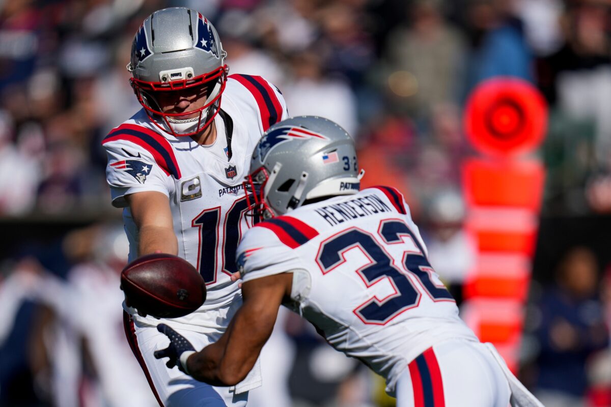 New England Patriots quarterback Drake Maye (10) hands off to running back TreVeyon Henderson (32) in the first quarter of the NFL Week 12 game between the Cincinnati Bengals and the New England Patriots at Paycor Stadium in downtown Cincinnati.