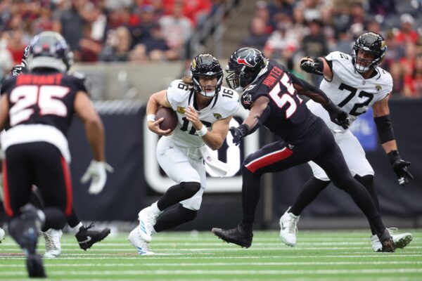 Jacksonville Jaguars quarterback Trevor Lawrence (16) scrambles with the ball against the Houston Texans during the first half at NRG Stadium.