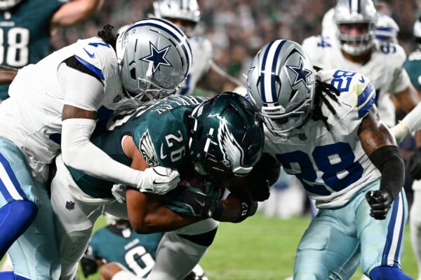 Philadelphia Eagles running back Saquon Barkley (26) carries the ball for a touchdown defended by Dallas Cowboys cornerback Trevon Diggs (7) and safety Malik Hooker (28) during the second quarter of the game at Lincoln Financial Field.