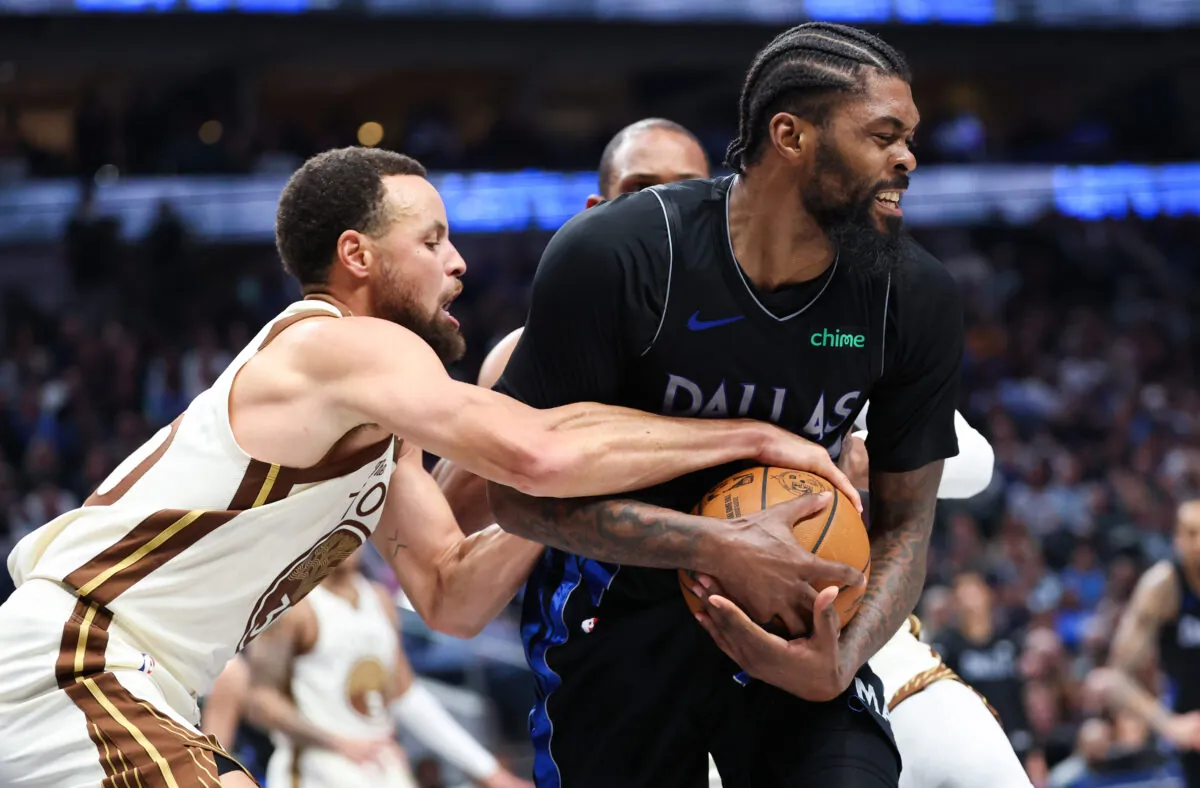 Curry cerca di rubare palla a Naji Marshall durante Mavericks-Warriors