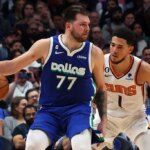 DALLAS, TEXAS - DECEMBER 05: Luka Doncic #77 of the Dallas Mavericks is guarded by Devin Booker #1 of the Phoenix Suns in the second half at American Airlines Center on December 05, 2022 in Dallas, Texas.