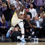 SACRAMENTO, CALIFORNIA - APRIL 17: Draymond Green #23 of the Golden State Warriors steps over Domantas Sabonis #10 of the Sacramento Kings in the second half during Game Two of the Western Conference First Round Playoffs at Golden 1 Center on April 17, 2023 in Sacramento, California. Green was issued a flagrant foul 2 on the play, and ejected from the game.