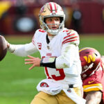 LANDOVER, MARYLAND - DECEMBER 31: Brock Purdy #13 of the San Francisco 49ers looks to pass under pressure during the second quarter of a game against the Washington Commanders at FedExField on December 31, 2023 in Landover, Maryland.