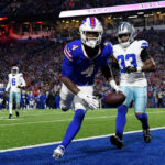 ORCHARD PARK, NEW YORK - DECEMBER 17: James Cook #4 of the Buffalo Bills catches a touchdown pass in front of Damone Clark #33 of the Dallas Cowboys during the second quarter at Highmark Stadium on December 17, 2023 in Orchard Park, New York