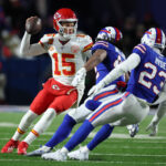 ORCHARD PARK, NEW YORK - JANUARY 21: Patrick Mahomes #15 of the Kansas City Chiefs dodges Micah Hyde #23 of the Buffalo Bills during their AFC Divisional Playoff game at Highmark Stadium on January 21, 2024 in Orchard Park, New York.