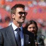 NFL legend Tom Brady is all smiles before an NFL football game at Huntington Bank Field, Sunday, Sept. 8, 2024, in Cleveland, Ohio.