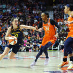 UNCASVILLE, CT - SEPTEMBER 22: Indiana Fever guard Caitlin Clark (22) drives to the basket against Connecticut Sun forward DeWanna Bonner (24) and Connecticut Sun forward Brionna Jones (42) during the First Round and game 1 of the 2024 WNBA playoffs between Indiana Fever and Connecticut Sun on September 22, 2024, at Mohegan Sun Arena in Uncasville, CT.