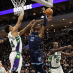 Jan 19, 2022; Milwaukee, Wisconsin, USA; Memphis Grizzlies guard Ja Morant (12) loses the ball under pressure from Milwaukee Bucks forward Giannis Antetokounmpo (34) during the second quarter at Fiserv Forum.
