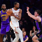 Jan 11, 2024; Los Angeles, California, USA; Phoenix Suns forward Kevin Durant (35) controls the ball against Los Angeles Lakers guard Austin Reaves (15) and forward LeBron James (23) during the second half at Crypto.com Arena.