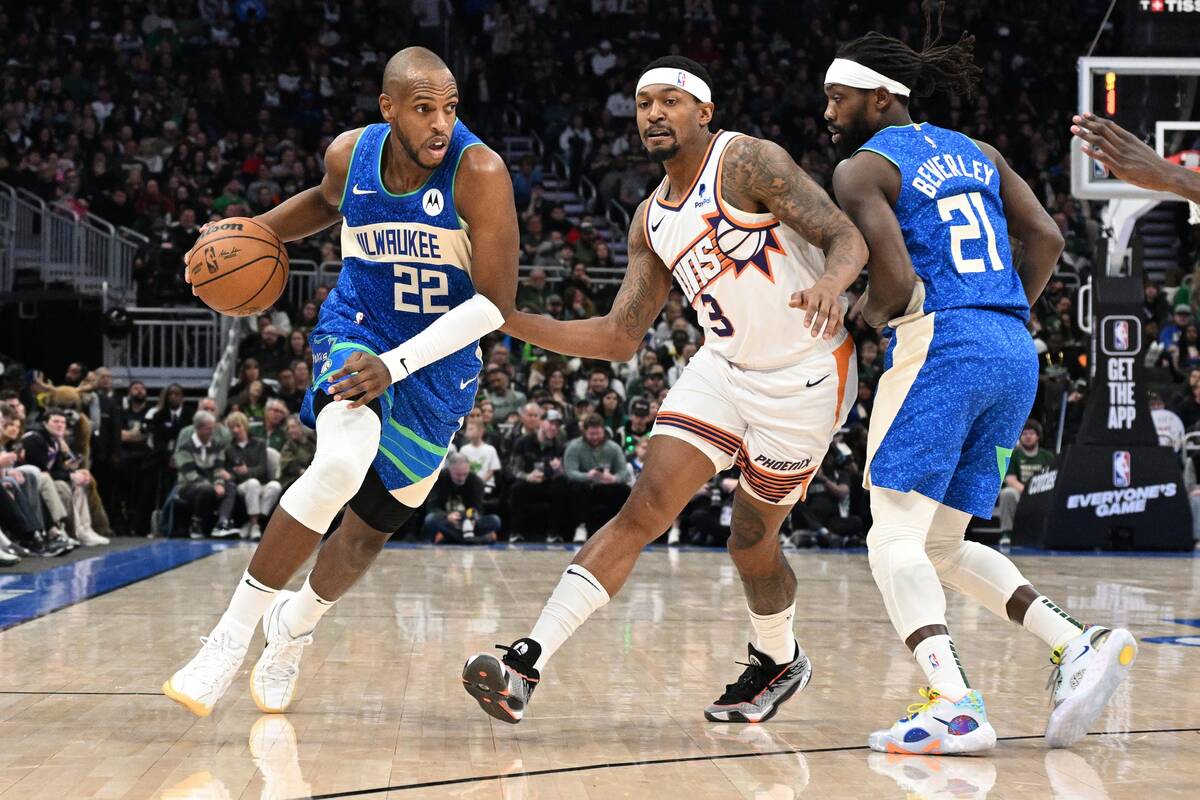 Mar 17, 2024; Milwaukee, Wisconsin, USA; Milwaukee Bucks forward Khris Middleton (22) drives to the basket against Phoenix Suns guard Bradley Beal (3) in the first half at Fiserv Forum. Mandatory Credit: Michael McLoone-USA TODAY Sports