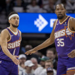 Apr 20, 2024; Minneapolis, Minnesota, USA; Phoenix Suns guard Devin Booker (1) shakes hands with forward Kevin Durant (35) against the Minnesota Timberwolves in the first half during game one of the first round for the 2024 NBA playoffs at Target Center.