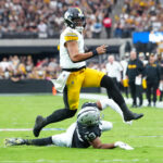 Oct 13, 2024; Paradise, Nevada, USA; Pittsburgh Steelers quarterback Justin Fields (2) evades the tackle attempt of Las Vegas Raiders defensive end Charles Snowden (49) during the second quarter at Allegiant Stadium. Mandatory Credit: Stephen R. Sylvanie-Imagn Images
