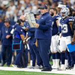 Oct 13, 2024; Arlington, Texas, USA; Dallas Cowboys Head Coach Mike McCarthy looks over the play chart during the first quarter against the Detroit Lions at AT&T Stadium. Jerry Jones. Mandatory Credit: Andrew Dieb-Imagn Images