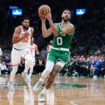 Oct 22, 2024; Boston, Massachusetts, USA; Boston Celtics forward Jayson Tatum (0) returns the ball to score against New York Knicks center Karl-Anthony Towns (32) in the first quarter at TD Garden.