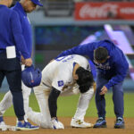 Oct 26, 2024; Los Angeles, California, USA; Los Angeles Dodgers manager Dave Roberts (30) and staff attend to designated hitter Shohei Ohtani (17) at second base after an apparent injury in the seventh inning against the New York Yankees during game two of the 2024 MLB World Series at Dodger Stadium. Mandatory Credit: Jayne Kamin-Oncea-Imagn Images
