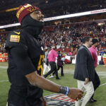 Oct 27, 2024; Landover, Maryland, USA;Washington Commanders quarterback Jayden Daniels (5) smiles while leaving the field after the Commanders' game against the Chicago Bears at Northwest Stadium. Mandatory Credit: Geoff Burke-Imagn Images