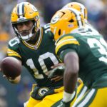 Oct 13, 2024; Green Bay, Wisconsin, USA; Green Bay Packers quarterback Jordan Love (10) hands the football off to running back Emanuel Wilson (31) during the fourth quarter against the Arizona Cardinals at Lambeau Field.