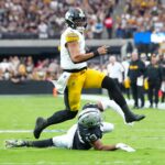Oct 13, 2024; Paradise, Nevada, USA; Pittsburgh Steelers quarterback Justin Fields (2) evades the tackle attempt of Las Vegas Raiders defensive end Charles Snowden (49) during the second quarter at Allegiant Stadium.