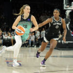 LAS VEGAS, NEVADA - OCTOBER 06: Sabrina Ionescu #20 of the New York Liberty drives against Jackie Young #0 of the Las Vegas Aces in the third quarter of Game Four of the 2024 WNBA Playoffs semifinals at Michelob ULTRA Arena on October 06, 2024 in Las Vegas, Nevada. The Liberty defeated the Aces 76-62 to win the series three games to one. NOTE TO USER: User expressly acknowledges and agrees that, by downloading and or using this photograph, User is consenting to the terms and conditions of the Getty Images License Agreement.