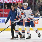 Edmonton Oilers defenseman Darnell Nurse (25) is helped off the ice after suffering an apparent injury on a bodycheck from Toronto Maple Leafs forward Ryan Reaves (not shown) in the second period at Scotiabank Arena.