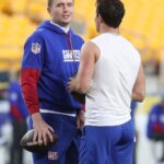 New York Giants quarterbacks Drew Lock (left) and Tommy DeVito (right) talk on the field before the game against the Pittsburgh Steelers at Acrisure Stadium.