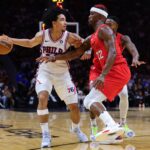 Philadelphia 76ers guard Jared McCain (20) protects the basketball from Miami Heat forward Jimmy Butler (22) during the third quarter at Kaseya Center.