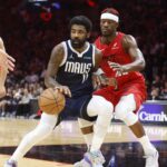 Miami Heat forward Jimmy Butler (22) defends Dallas Mavericks guard Kyrie Irving (11) during overtime at Kaseya Center.