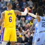 Dec 29, 2021; Memphis, Tennessee, USA; Memphis Grizzlies guard Ja Morant (12) grabs the hand of Los Angeles Lakers forward LeBron James (6) after James makes a three point shot during the second half at the FedExForum.