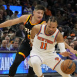 Dec 15, 2023; Phoenix, Arizona, USA; New York Knicks guard Jalen Brunson (11) drives on Phoenix Suns guard Grayson Allen (8) in the second half at Footprint Center.