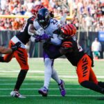 Cincinnati Bengals cornerback DJ Turner II (20), left and defensive end Myles Murphy (99) take down Baltimore Ravens running back Derrick Henry (22) during the 4th quarter Sunday October 6, 2024 at Payor Stadium. The Bengals lost to Baltimore Ravens 41-38 in overtime.