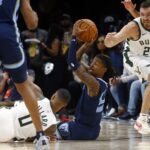 Oct 31, 2024; Memphis, Tennessee, USA; Memphis Grizzlies guard Ja Morant (12) passes the ball, while sitting on the court, to forward Santi Aldama (not pictured) for an ally-app dunk during the first half against the Milwaukee Bucks at FedExForum. Mandatory Credit: Petre Thomas-Imagn Images