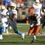 Nov 3, 2024; Cleveland, Ohio, USA; Los Angeles Chargers wide receiver Quentin Johnston (1) runs the ball as Cleveland Browns cornerback Denzel Ward (21) chases him during the second quarter at Huntington Bank Field. Mandatory Credit: Scott Galvin-Imagn Images