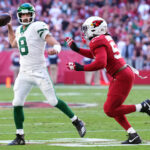 Nov 10, 2024; Glendale, Arizona, USA; New York Jets quarterback Aaron Rodgers (8) throws while being chased by Arizona Cardinals linebacker Baron Browning (53) during the first half at State Farm Stadium. Mandatory Credit: Joe Camporeale-Imagn Images