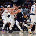 Nov 10, 2024; Denver, Colorado, USA; Denver Nuggets center Nikola Jokic (15) passes the ball away from Dallas Mavericks guard Luka Doncic (77) in the second half at Ball Arena. Mandatory Credit: Ron Chenoy-Imagn Images
