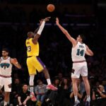 Nov 13, 2024; Los Angeles, California, USA; Los Angeles Lakers forward LeBron James (23) shoots the ball over Memphis Grizzlies center Zach Edey (14) during the fourth quarter at Crypto.com Arena. Mandatory Credit: Kiyoshi Mio-Imagn Images