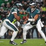 Nov 14, 2024; Philadelphia, Pennsylvania, USA; Philadelphia Eagles quarterback Jalen Hurts (1) hands off to running back Saquon Barkley (26) against the Washington Commanders during the first quarter at Lincoln Financial Field.