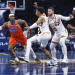 Nov 15, 2024; Oklahoma City, Oklahoma, USA;Oklahoma City Thunder guard Shai Gilgeous-Alexander (2) passes the ball to guard Luguentz Dort (5) around Phoenix Suns forward Ryan Dunn (0) during the fourth quarter at Paycom Center. Mandatory Credit: Alonzo Adams-Imagn Images