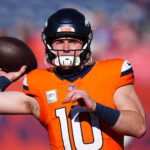 Nov 17, 2024; Denver, Colorado, USA; Denver Broncos quarterback Bo Nix (10) warms before the game against the Atlanta Falcons at Empower Field at Mile High. Mandatory Credit: Ron Chenoy-Imagn Images